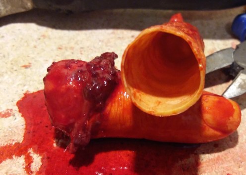 Simulador de hemorragia con detalles realistas, mostrando un cono y simulación de tejido sanguinolento.